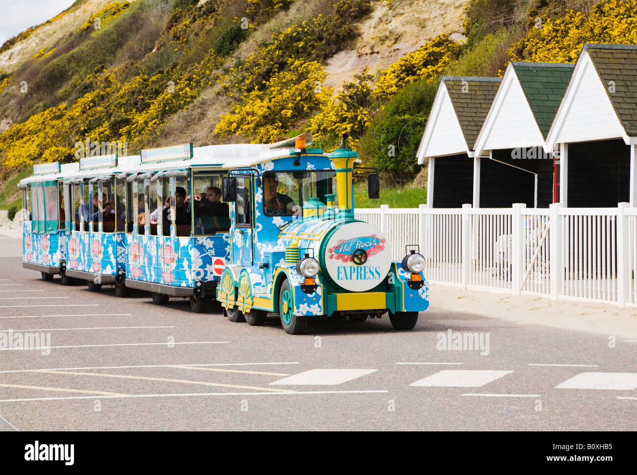 Uno dei due treni di terra che corrono lungo il fronte mare di Bournemouth di fronte alla spiaggia di capanne. Il Dorset. Regno Unito. Foto Stock