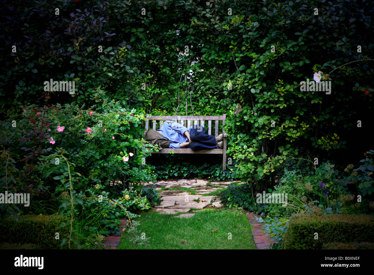 Uomo di dormire su una panchina di Shakespeare giardino disegnato da Jens Jensen e fondata nel 1915 a CHICAGO periferia nord di Evan Foto Stock