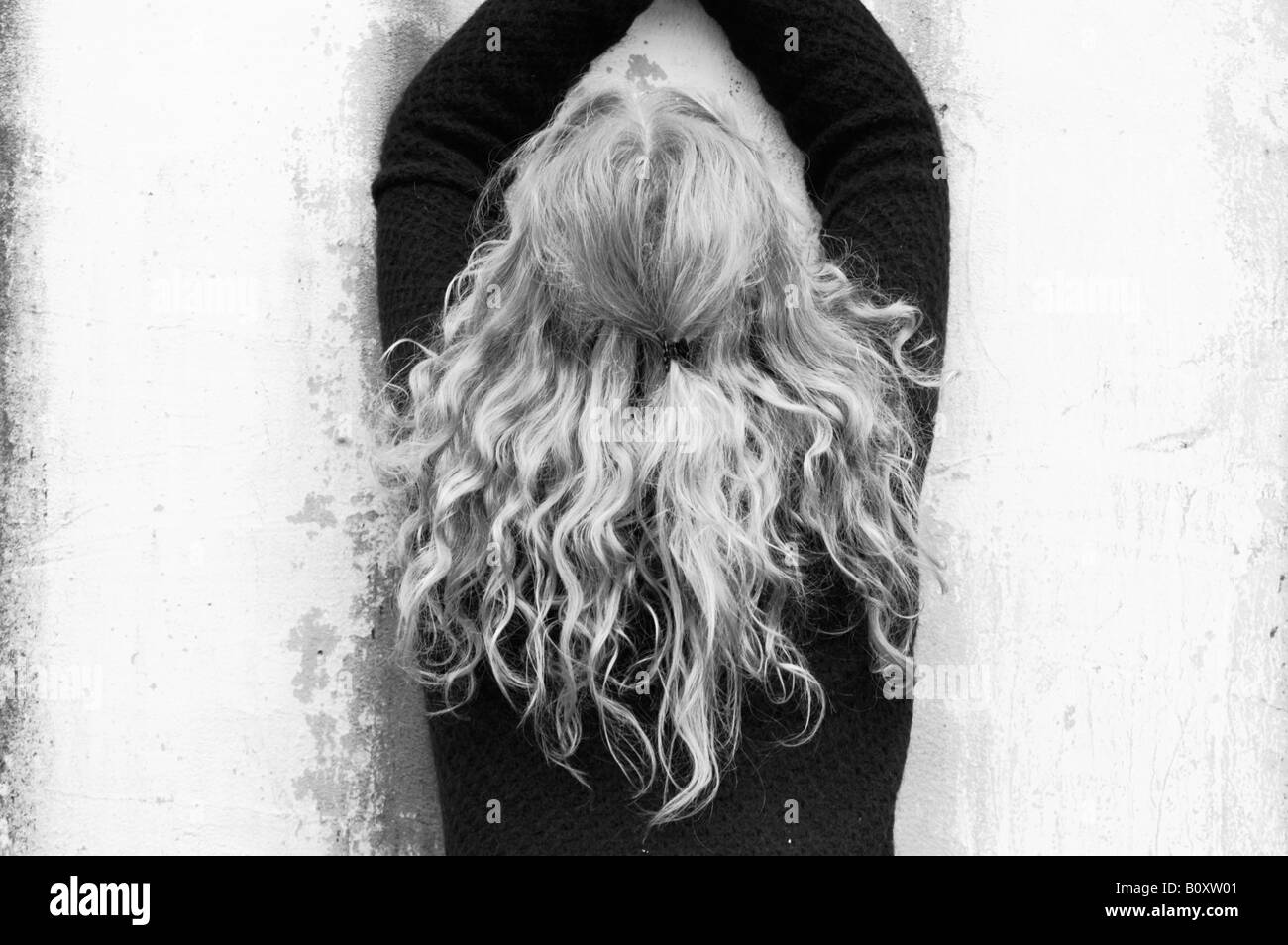 Ragazza con lunghi capelli biondi davanti a una parete bianca, Germania Foto Stock