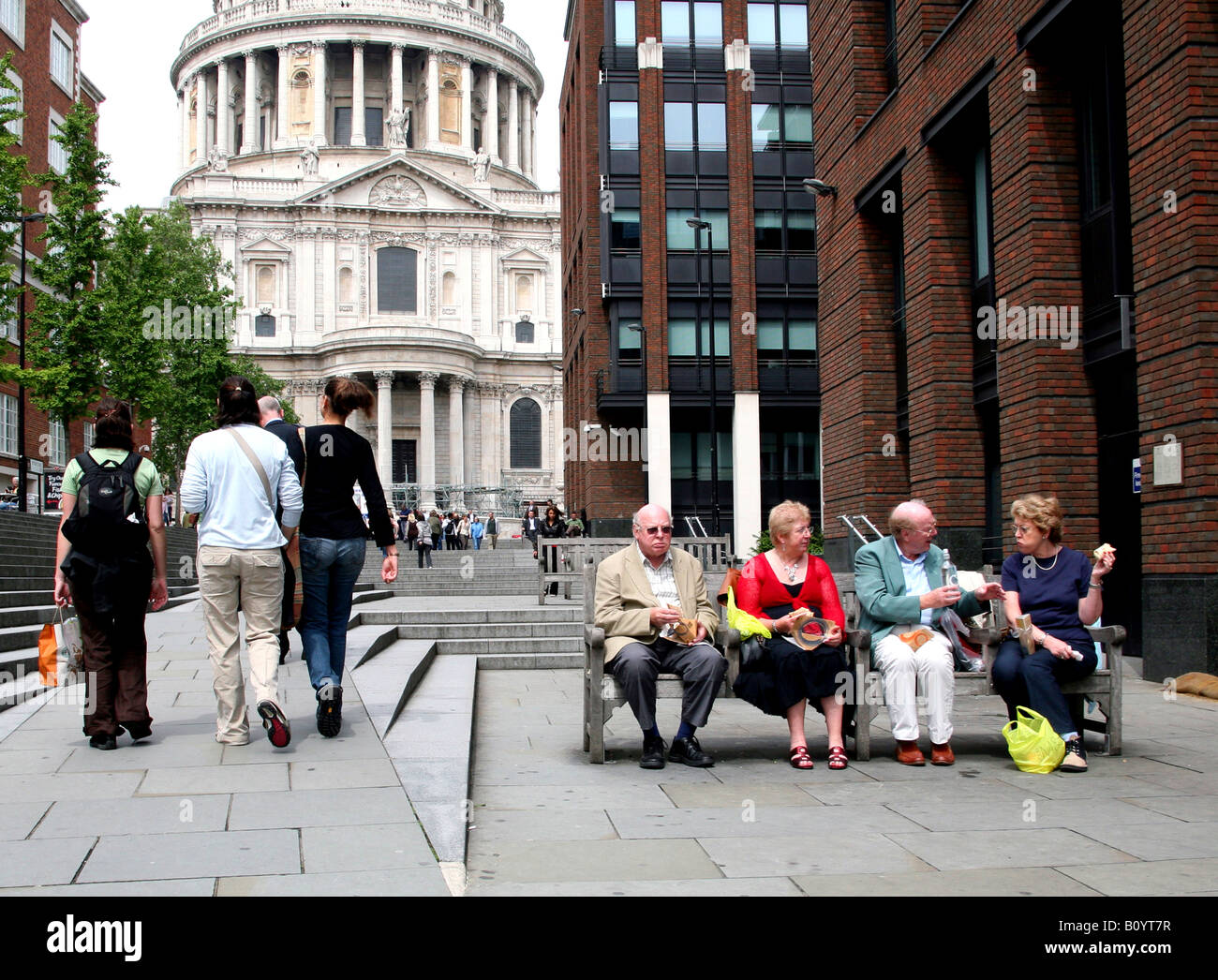 Le persone anziane godetevi il pranzo al sacco sul banco vicino alla Cattedrale di St Paul, Londra Foto Stock