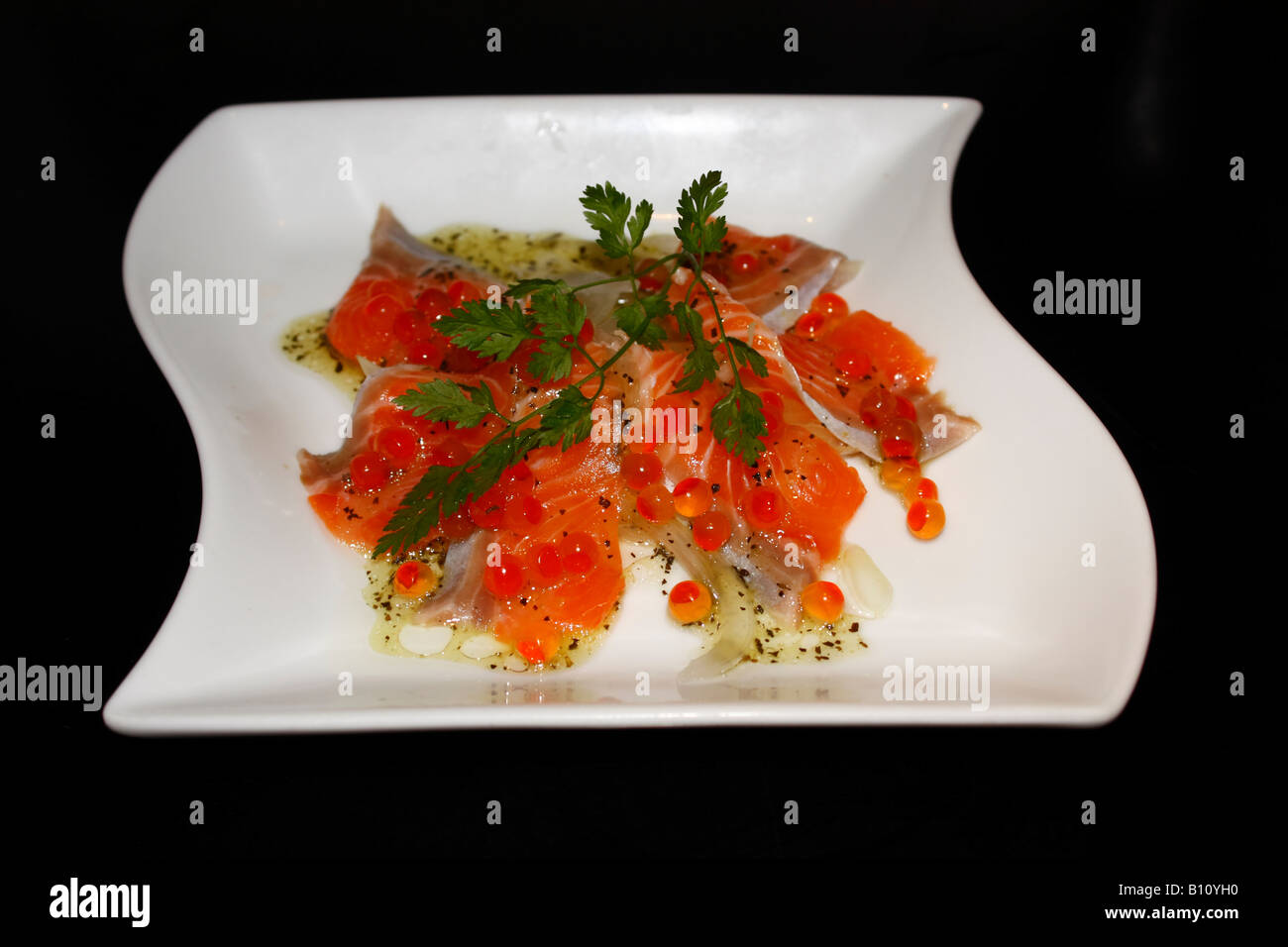 Una piastra di stile Japanesse marinato (souced) fumi di salmone con cipolla e uova di salmone Foto Stock