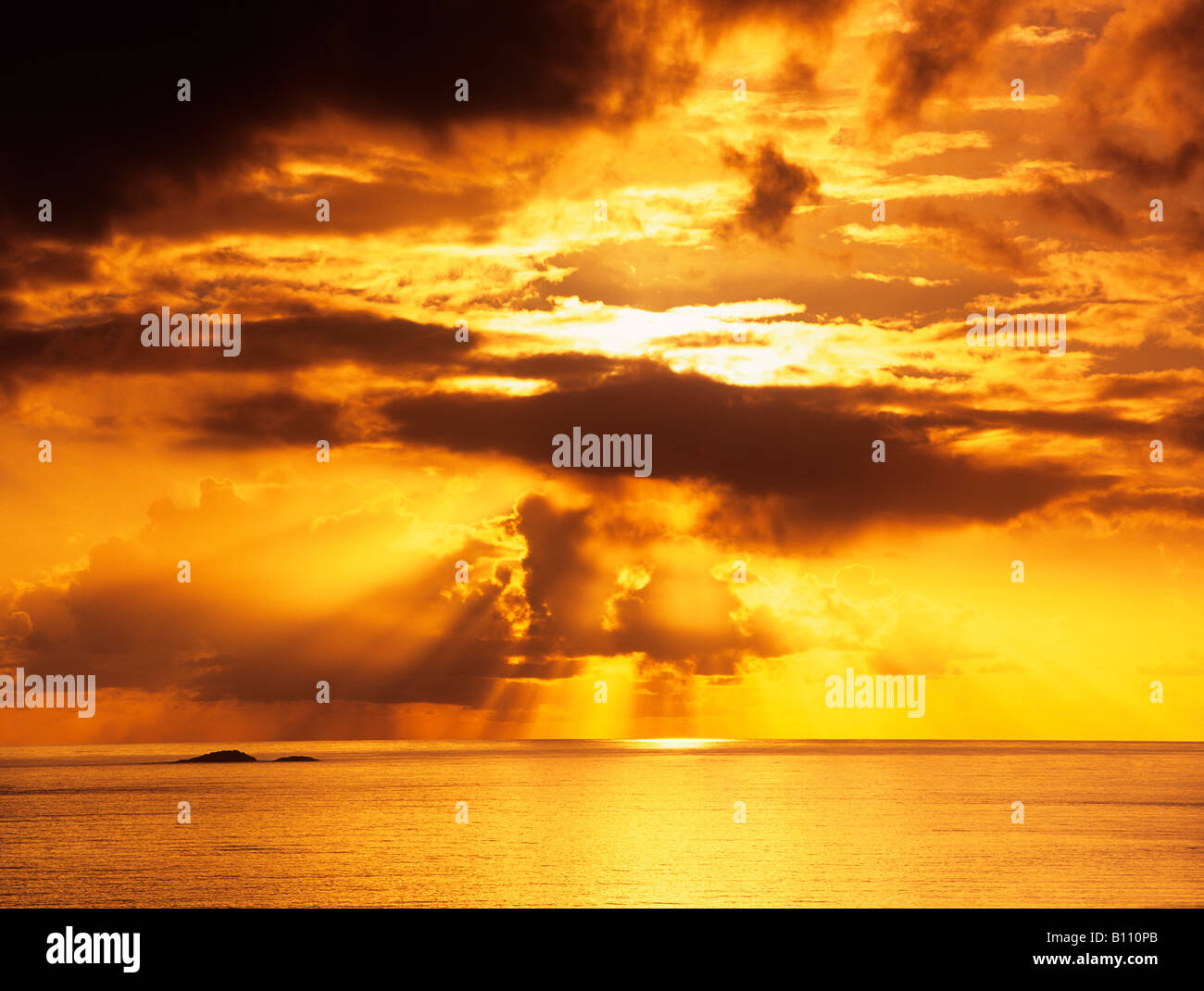 Incredibile drammatico golden arancione tramonto con le nuvole e arancione tramonto sul mare calmo oceano su Scottish west coast in autunno. Scozia UK Gran Bretagna Foto Stock