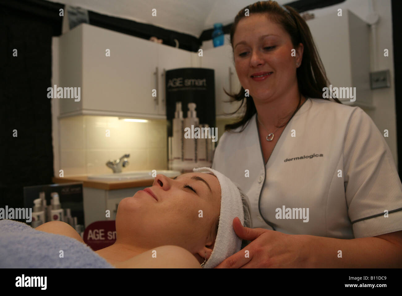 Una salute e bellezza technitian dando una bella donna un trattamento del viso Foto Stock