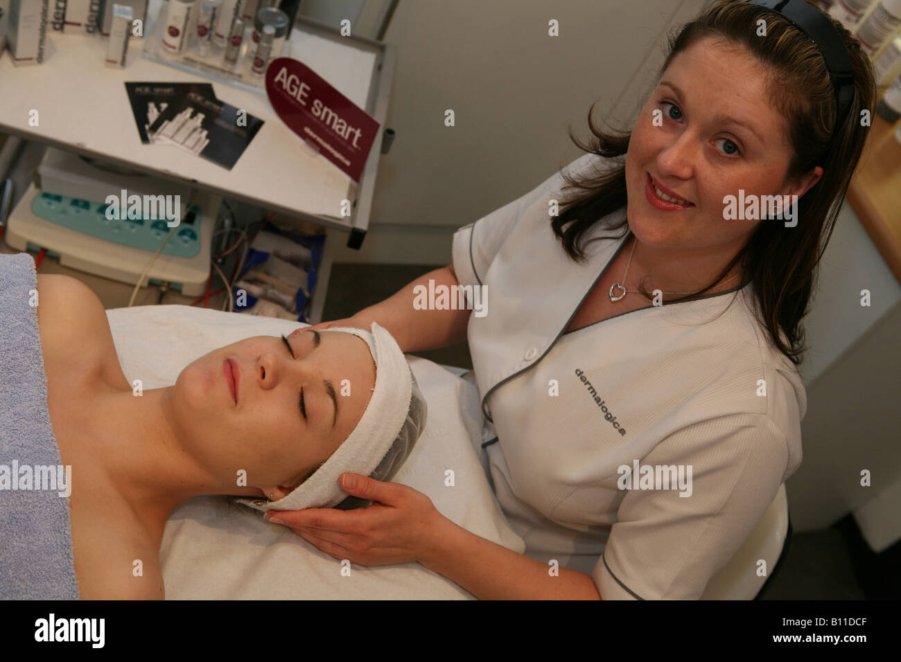 Una salute e bellezza technitian dando una bella donna un trattamento del viso Foto Stock