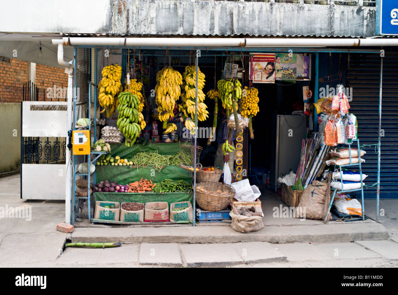 INDIA Kerala KOCHI piccolo negozio che vende frutta fresca incluse le banane sulla levetta verdura pane e riso in Kochi Foto Stock