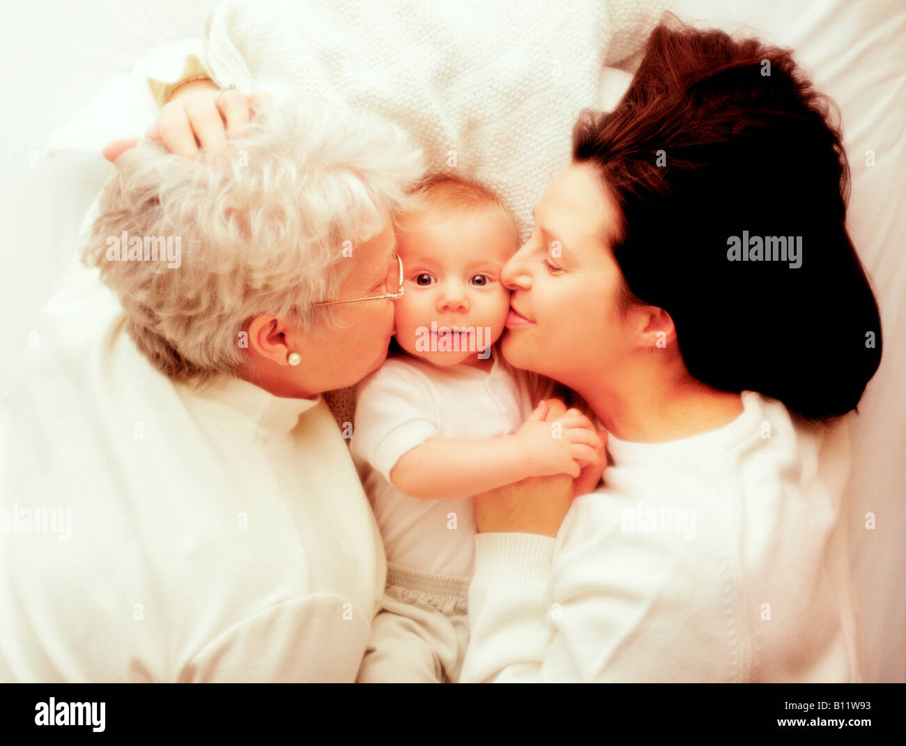Madre e nonna snuggling con baby boy Foto Stock