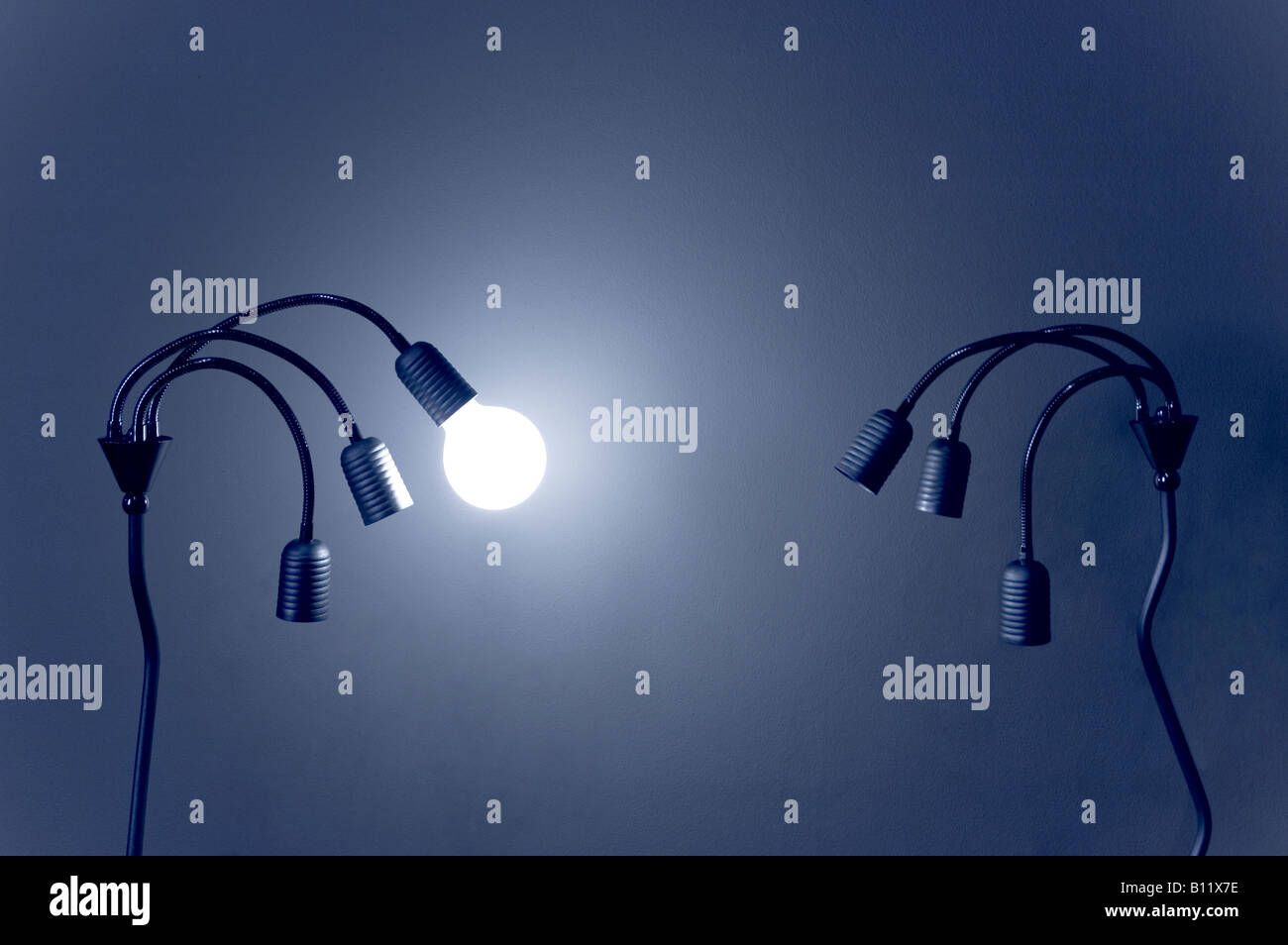 Luce pallido su una commutazione off moderni lampadari con singolo di tungsteno della lampadina luce su blu Foto Stock