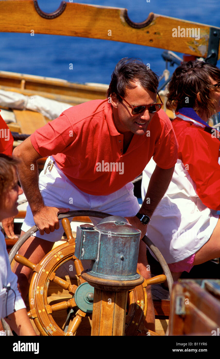 Il capitano di un antico schooner mans il timone durante una gara nello stretto di Juan de Fuca Foto Stock