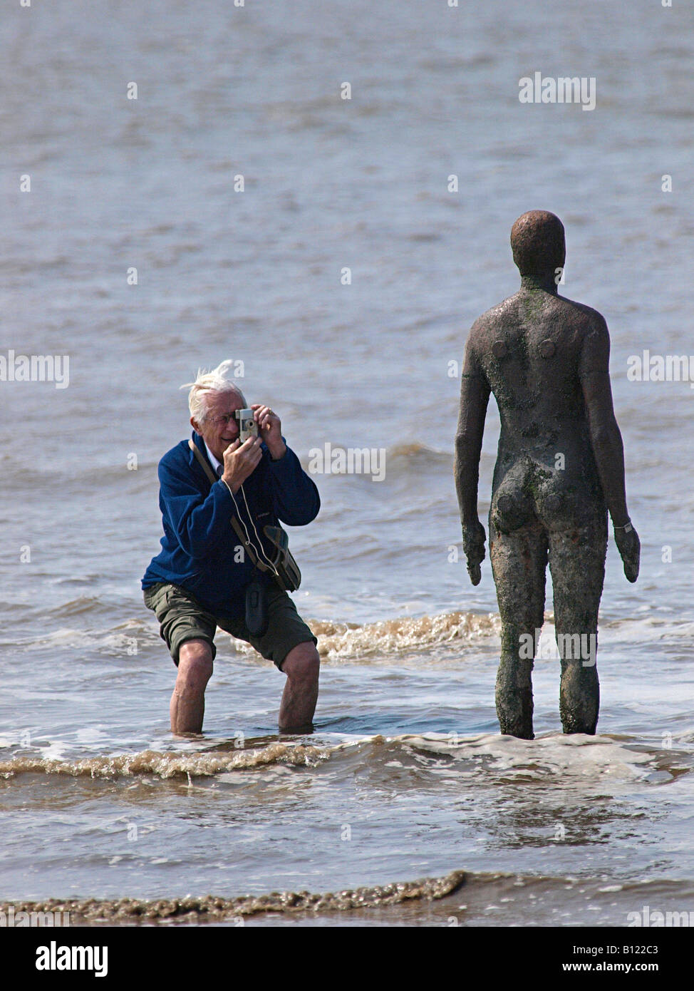 ANTONY GORMLEY scolpita la figura sulla spiaggia a Crosby che è fotografata dal visitatore , Liverpool, Merseyside England,UK, Foto Stock