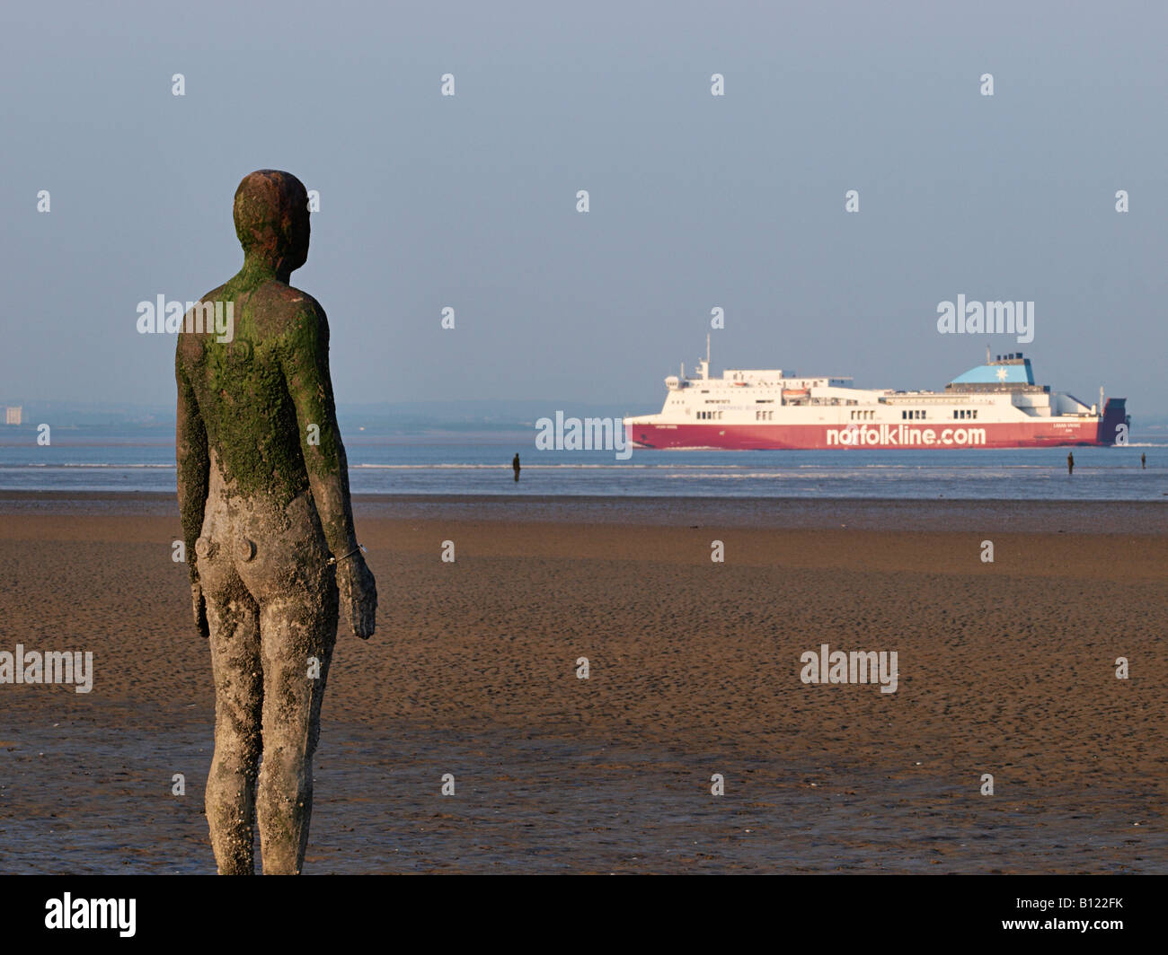 Antony Gormley scolpita la figura sulla spiaggia con passaggio nave sul fiume Mersey , Crosby, Liverpool, Merseyside England,uk, Foto Stock
