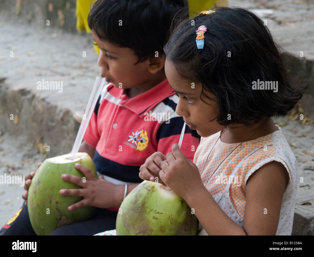 Fratello e Sorella sorseggiando noci di cocco in India Foto Stock