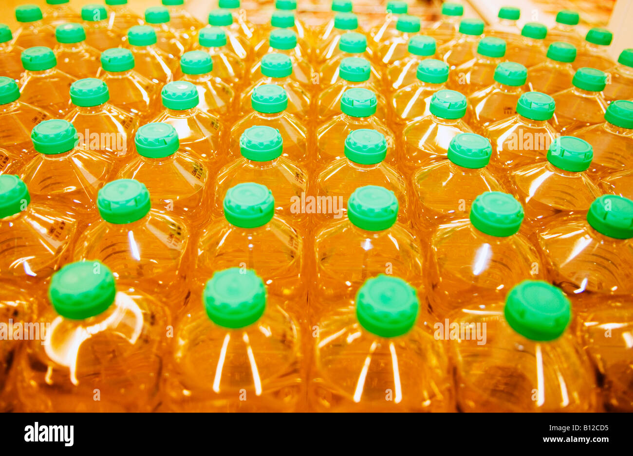 Righe di olio da cucina in bottiglie di plastica su scaffale di supermercato Foto Stock