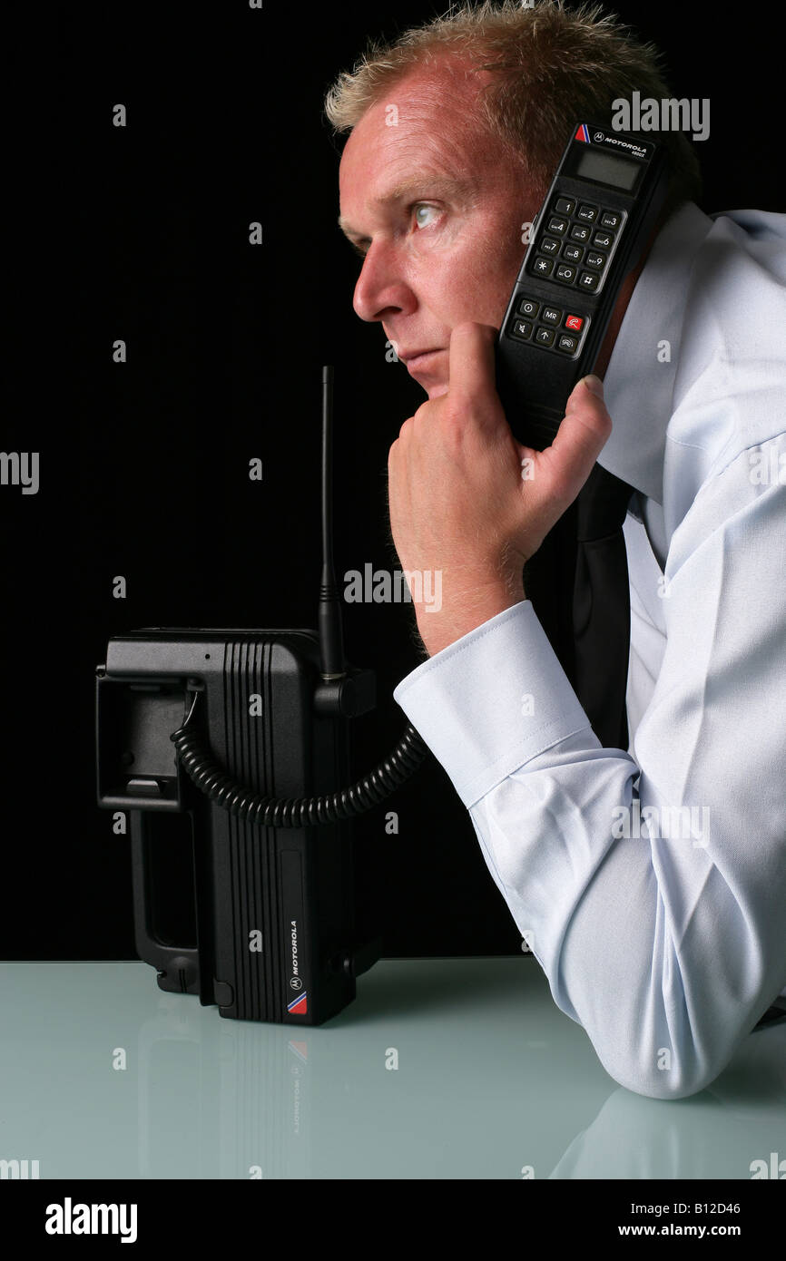 [Modello maschio utilizzando un motorola transprtable telefono che è di circa 20 anni] Foto Stock