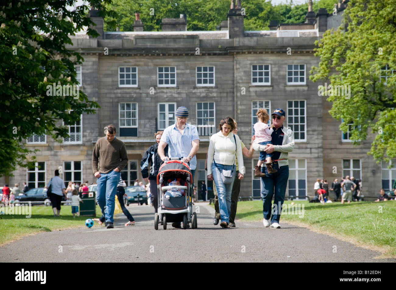 La gente a passeggiare al sole presso Haigh Hall Country Park Wigan Lancashire pomeriggio estivo Foto Stock