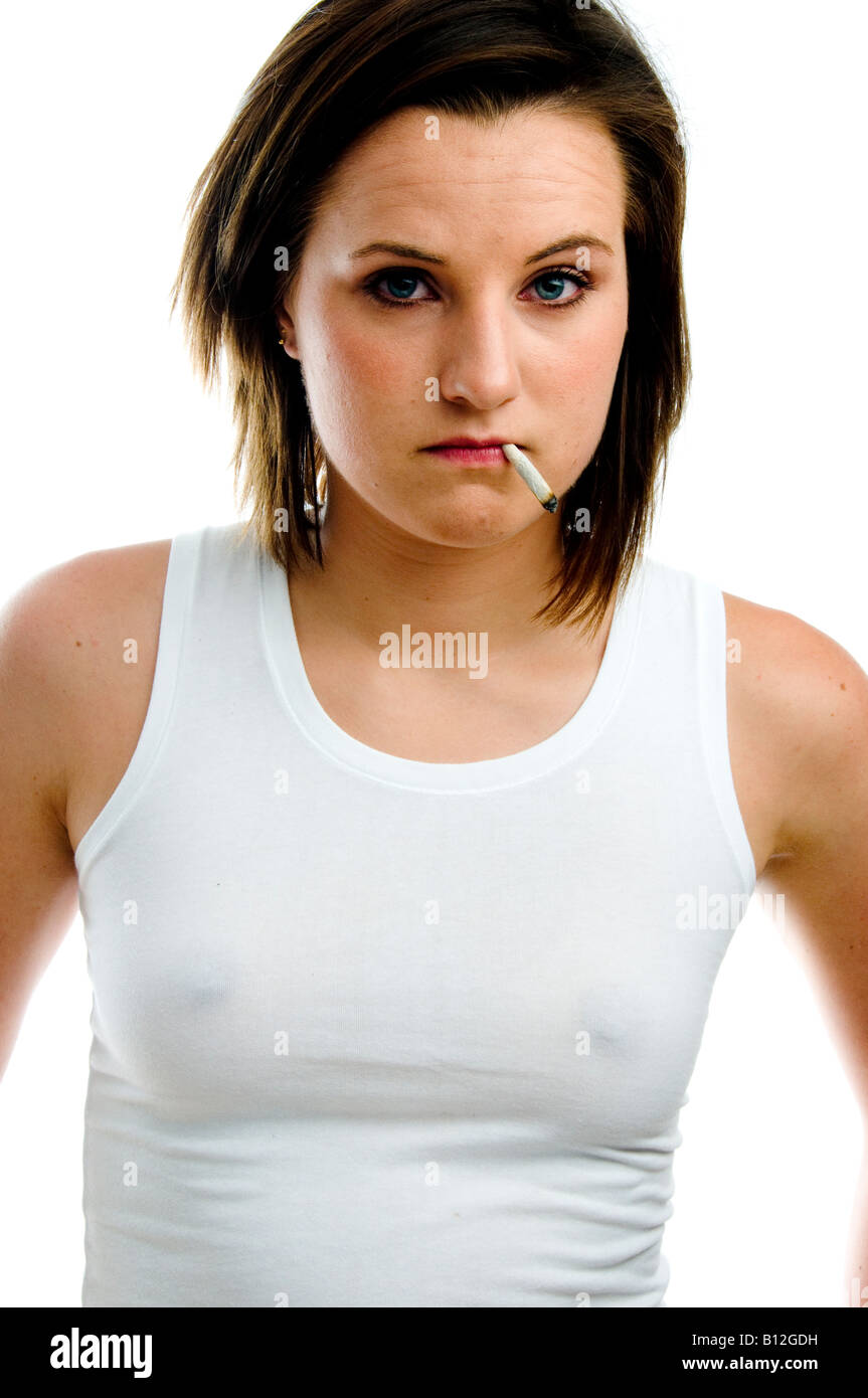 Moody cercando inglese diciannovenne ragazza adolescente indossando bianco Gilet fumatori arrotolate a mano sigaretta, REGNO UNITO Foto Stock