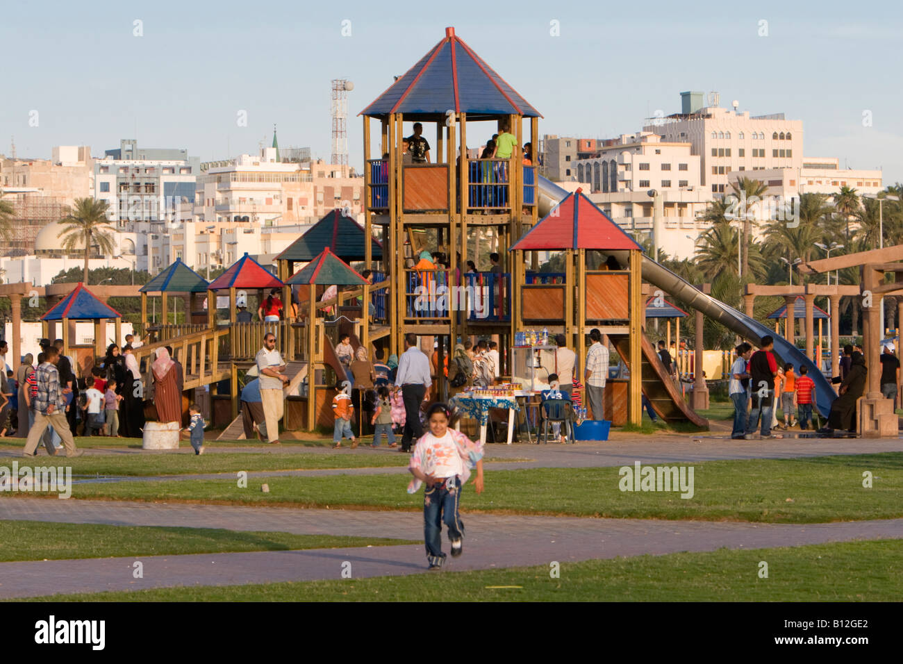 Tripoli, Libia, Nord Africa. Nel pomeriggio il parco pubblico Parco giochi vicino a piazza verde. I bambini sulla slitta, ragazza in esecuzione. Foto Stock