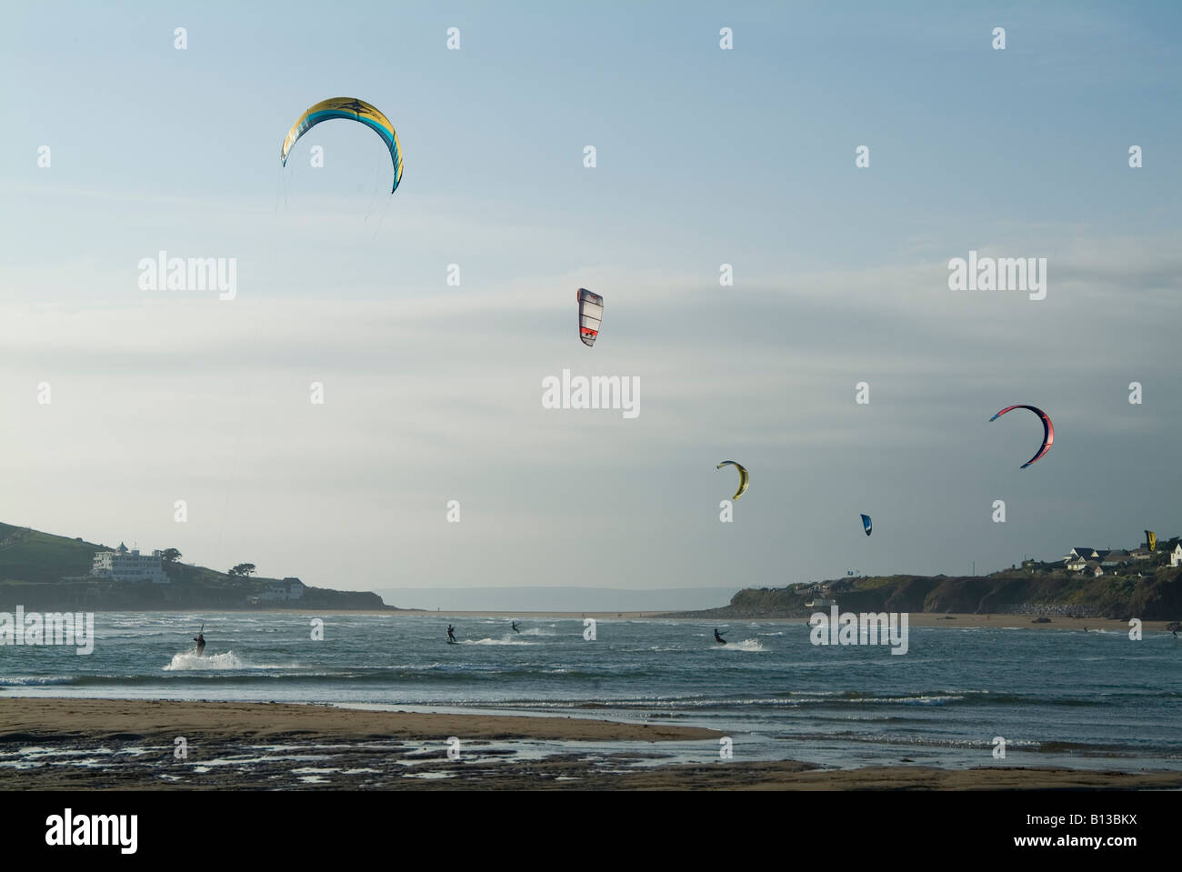 Gli appassionati di kitesurf in una giornata fredda inverni al largo di Bantham Beach, South Devon. REGNO UNITO Foto Stock