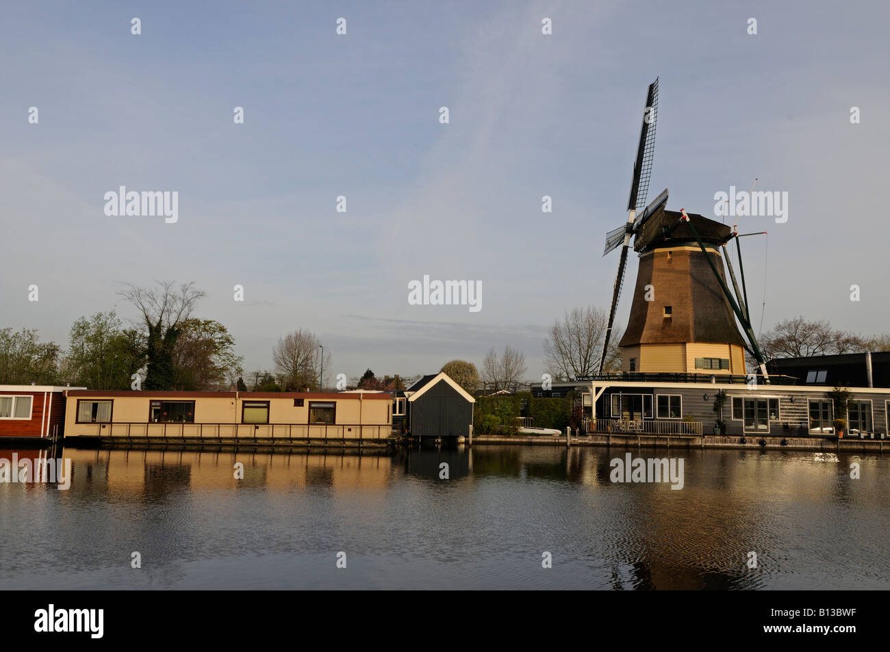 Tradizionale mulino a vento olandese e moderne case galleggianti al fiume Vecht Vreeland Paesi Bassi Europa Foto Stock