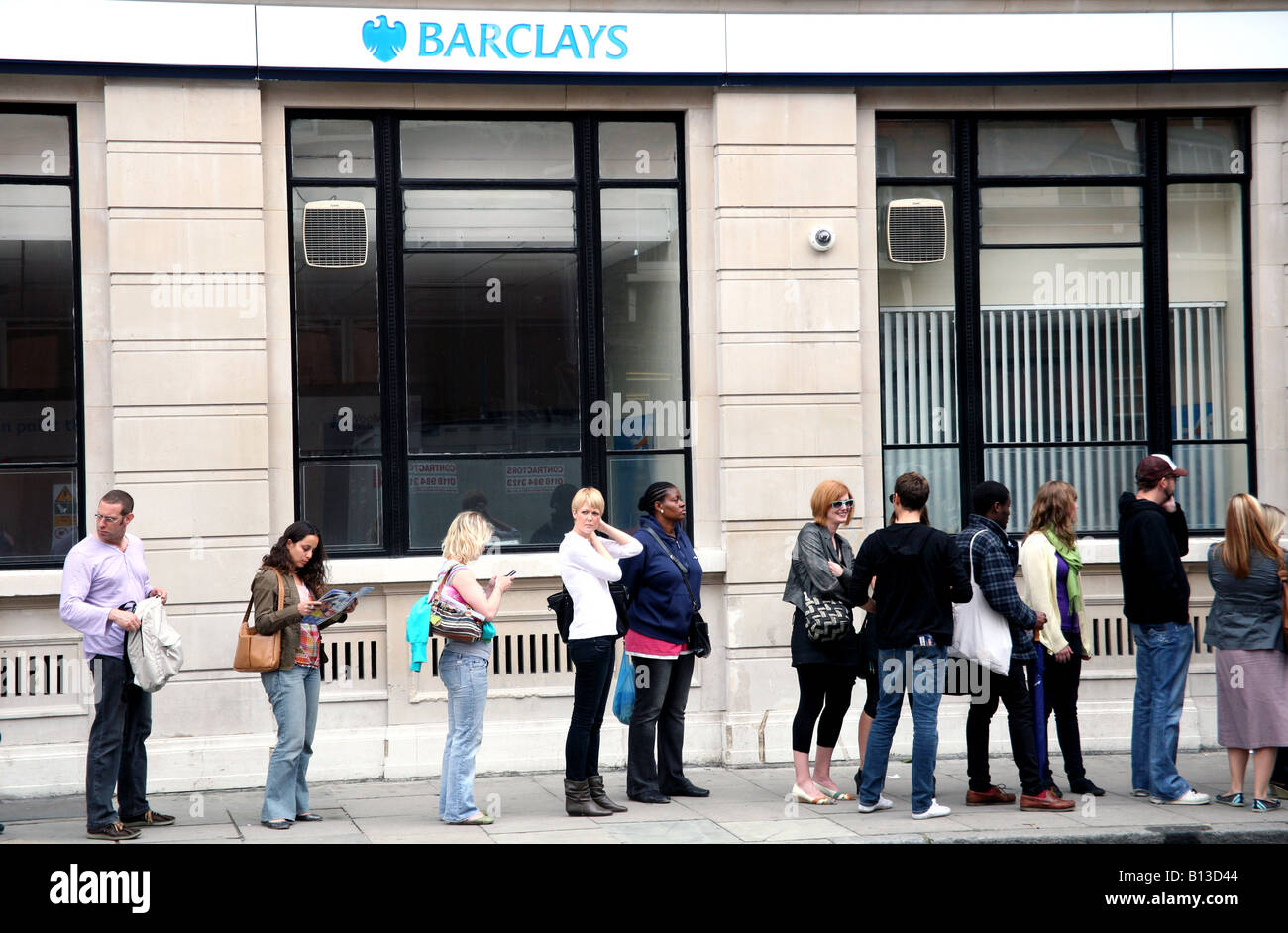 I clienti in coda per un bancomat in London street Foto Stock