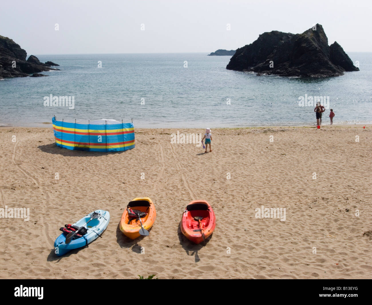 Tre canoe colorate e un interruttore a vento su una spiaggia di sabbia. Soar Mill Cove, South Hams, South Devon. REGNO UNITO Foto Stock