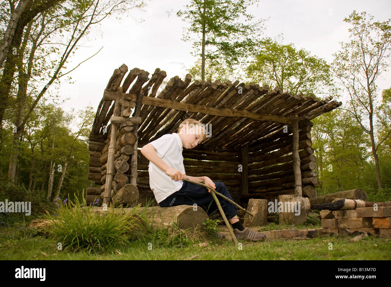 Giovane ragazzo in log cabin in un legno Foto Stock