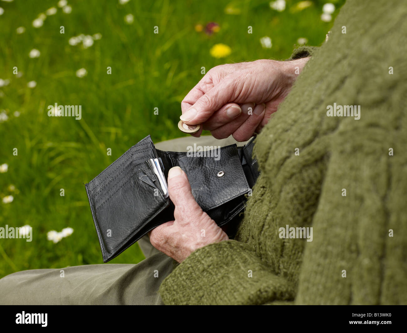 Vecchie mani di un senior contando meno soldi in una borsa Foto Stock