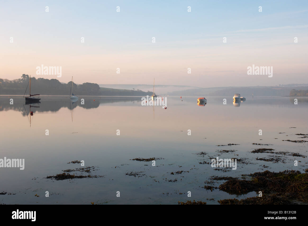 Yacht e Barche da pesca catture le prime luci dell alba sulle Misty Kingsbridge estuario Devon UK Foto Stock