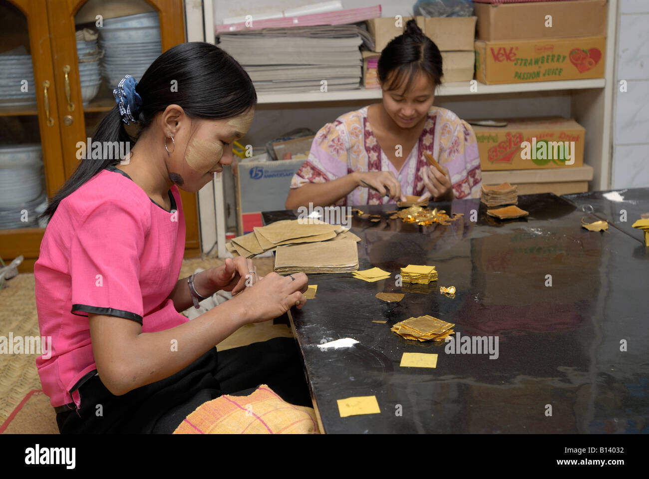 Oro battendo, giovani donne taglio e confezionamento foglia oro in carta di bambù, MANDALAY AMARAPURA, MYANMAR Birmania Birmania, ASIA Foto Stock