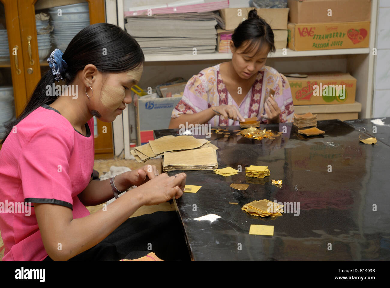 Oro battendo, giovani donne taglio e confezionamento foglia oro in carta di bambù, MANDALAY AMARAPURA, MYANMAR Birmania Birmania, ASIA Foto Stock