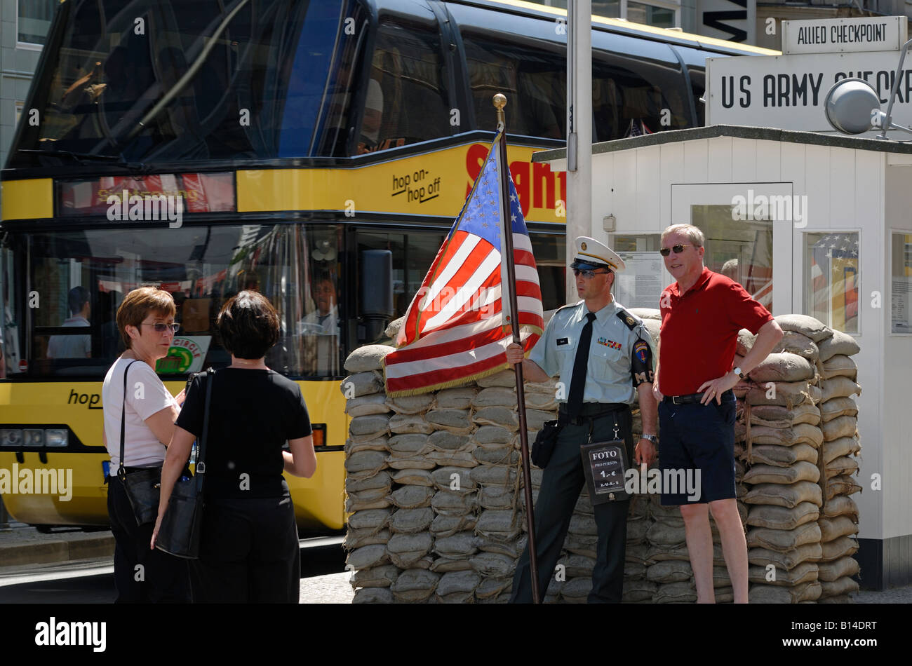 Berlino. Il Checkpoint Charlie oggi. Le forze alleate di frontiera del punto di controllo. Attore come soldato americano in posa con i turisti. Foto Stock