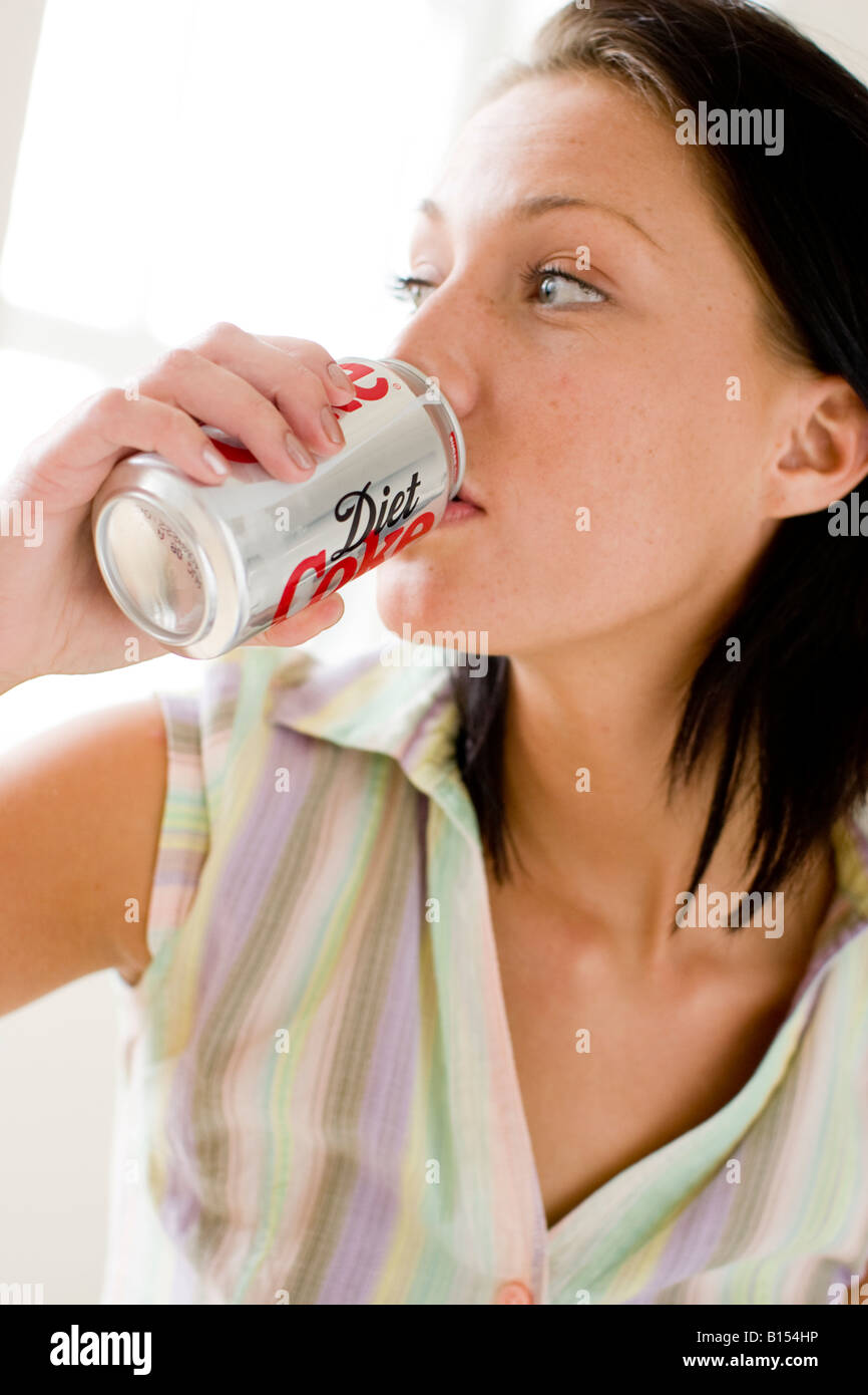 Ragazza bere da Cola può stagno Foto Stock