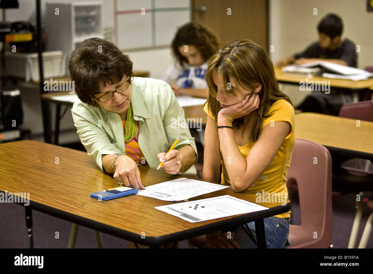 Un educatore specializzato in un Southern California middle school aiuta a uno studente con un problema di matematica Foto Stock