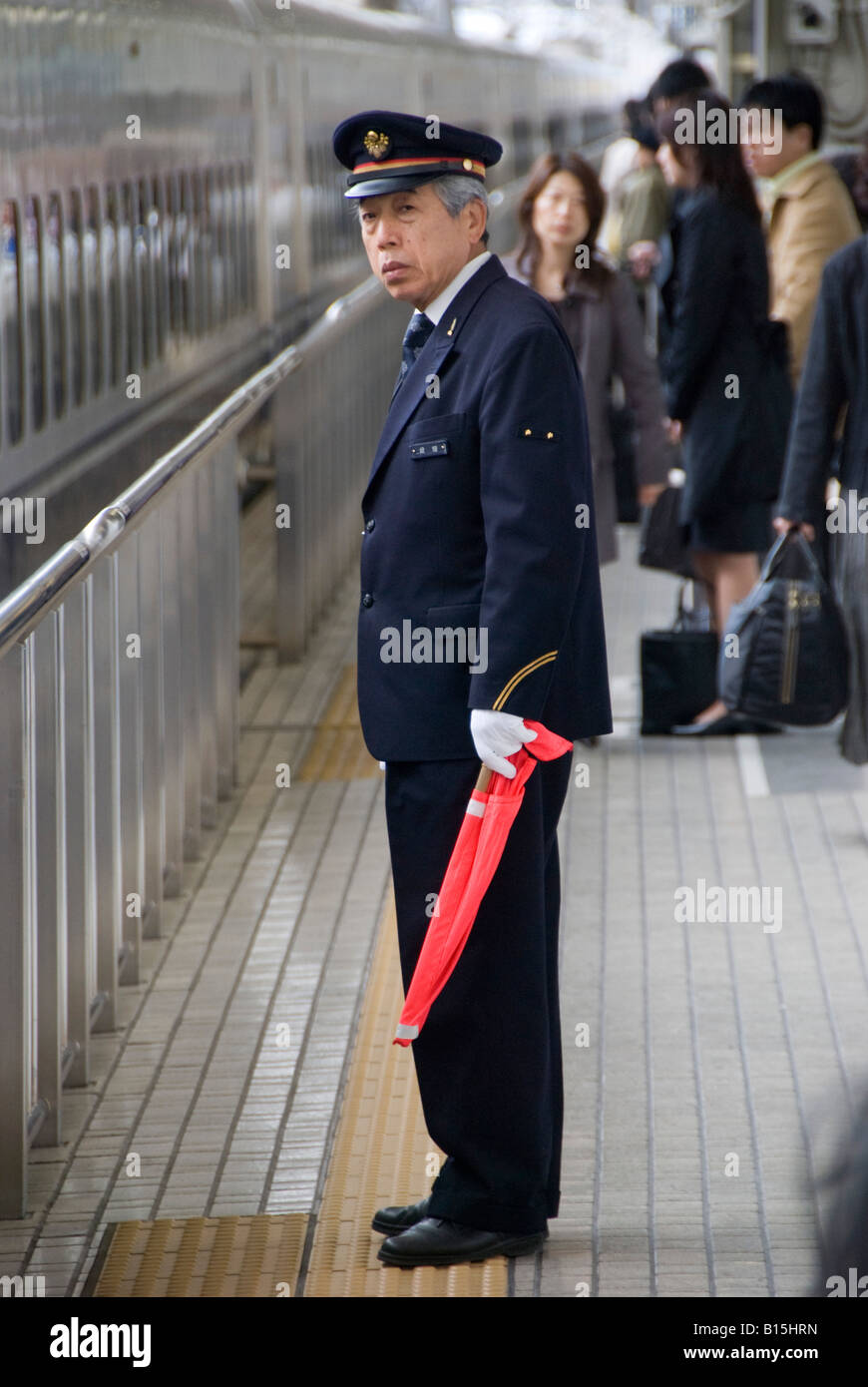 Kyoto, Giappone. Un bianco-ispettore guantata sul bullet train (Shinkansen) piattaforma a Kyoto Stazione Centrale Foto Stock