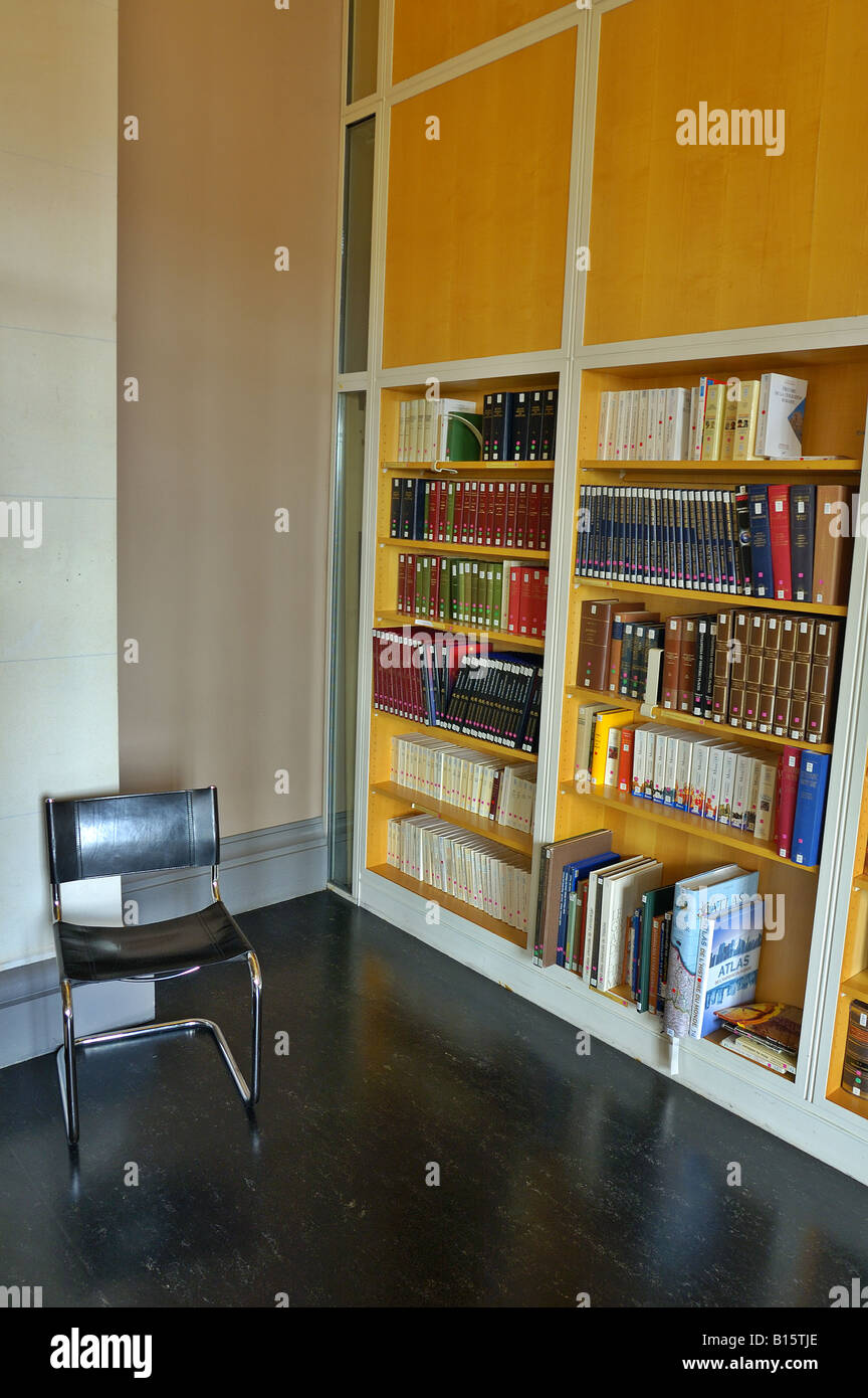 Una sedia vuota in un angolo di una libreria deserta Foto Stock