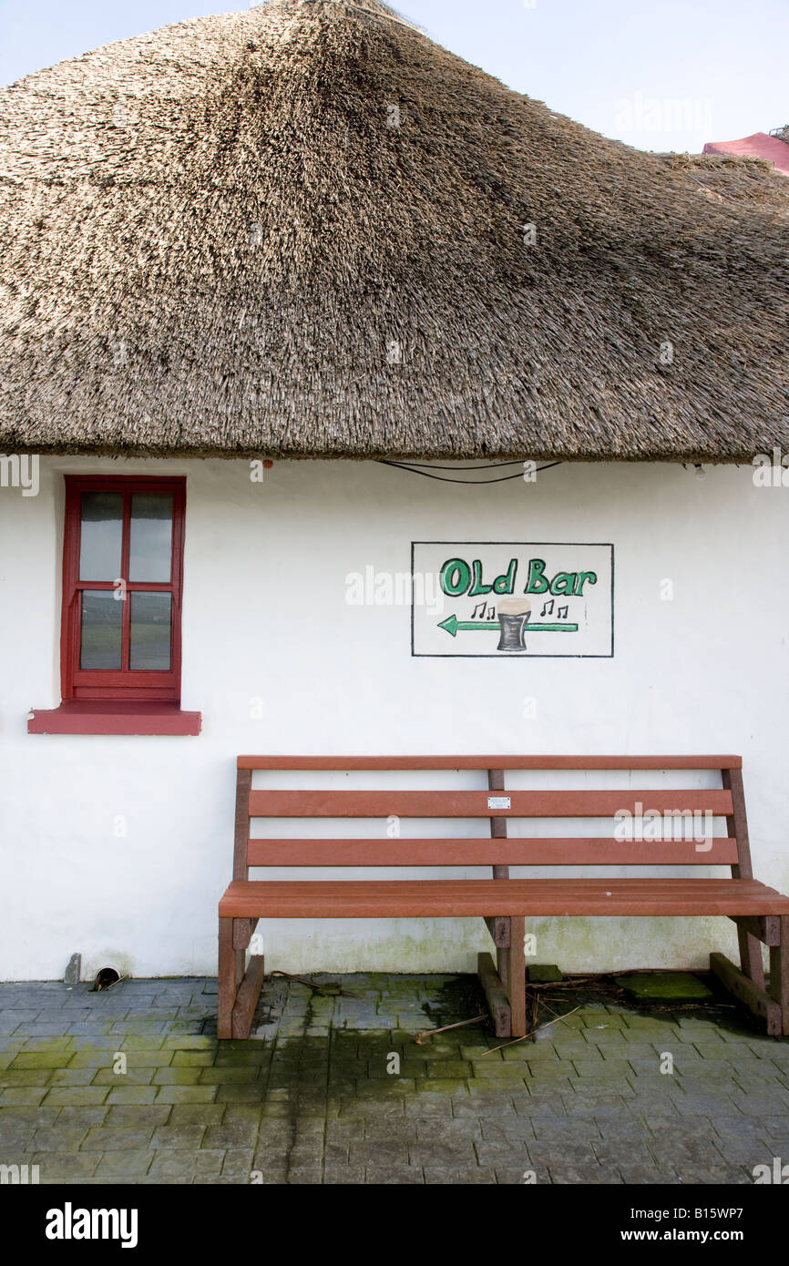 Esterno di un cottage con tetto di paglia e vecchi bar segno, nella contea di Clare Irlanda Foto Stock