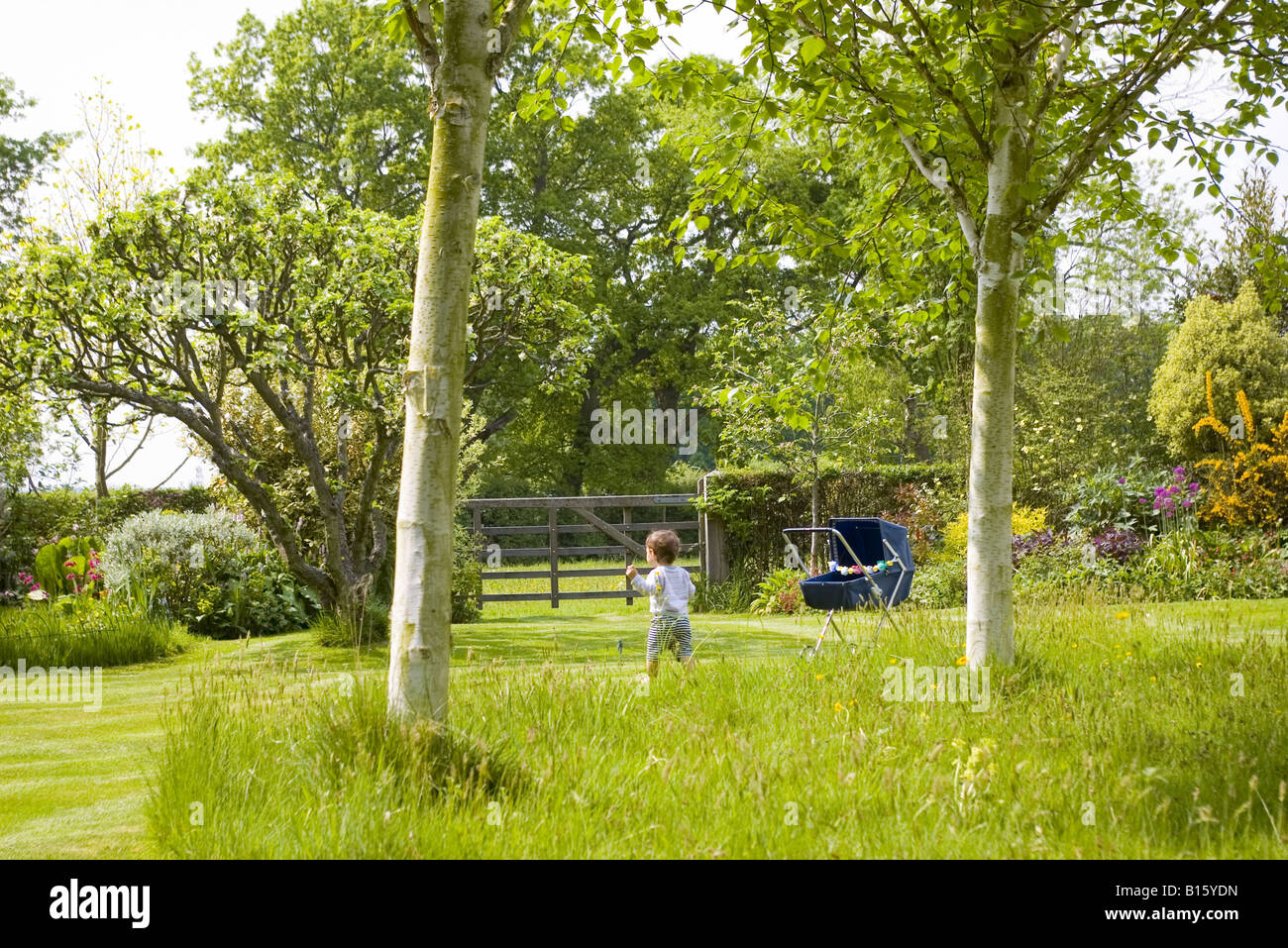 Un bambino piccolo a godersi il sole nel giardino in estate in campagna a Londra nel Regno Unito Foto Stock