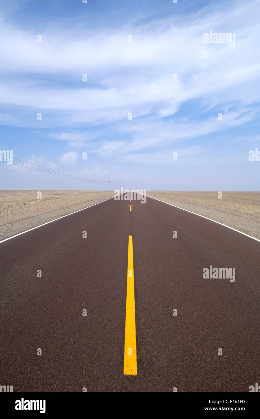 Parte del Pan American autostrada nel deserto centrato e conduce alla distanza con giallo linee divisorie e cielo blu. Foto Stock