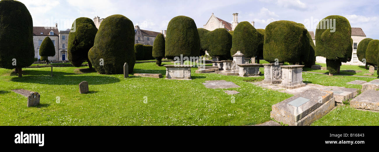 Pietra scolpita tombe e alcuni dei 99 yew alberi nel cimitero del villaggio Costwold di Painswick, Gloucestershire Foto Stock