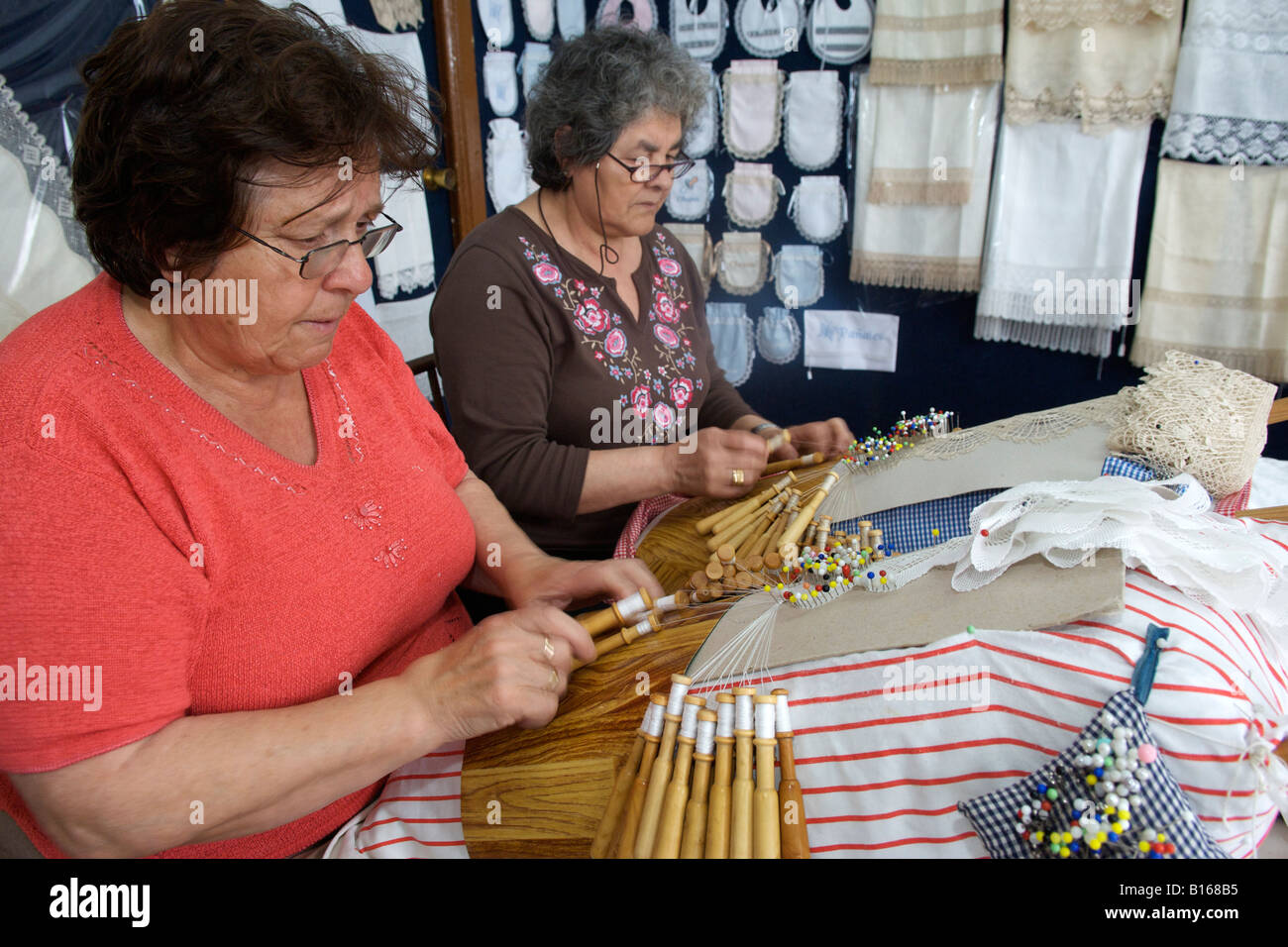 Donne spagnole in pizzo di tessitura sul loro perno gingham cuscini nel villaggio di Camariñas nella regione della Galizia di Spagna. Foto Stock