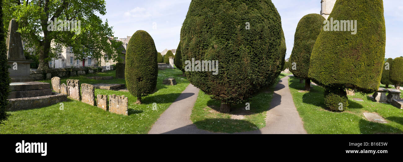 Pietra scolpita tombe e alcuni dei 99 yew alberi nel cimitero del villaggio Costwold di Painswick, Gloucestershire Foto Stock