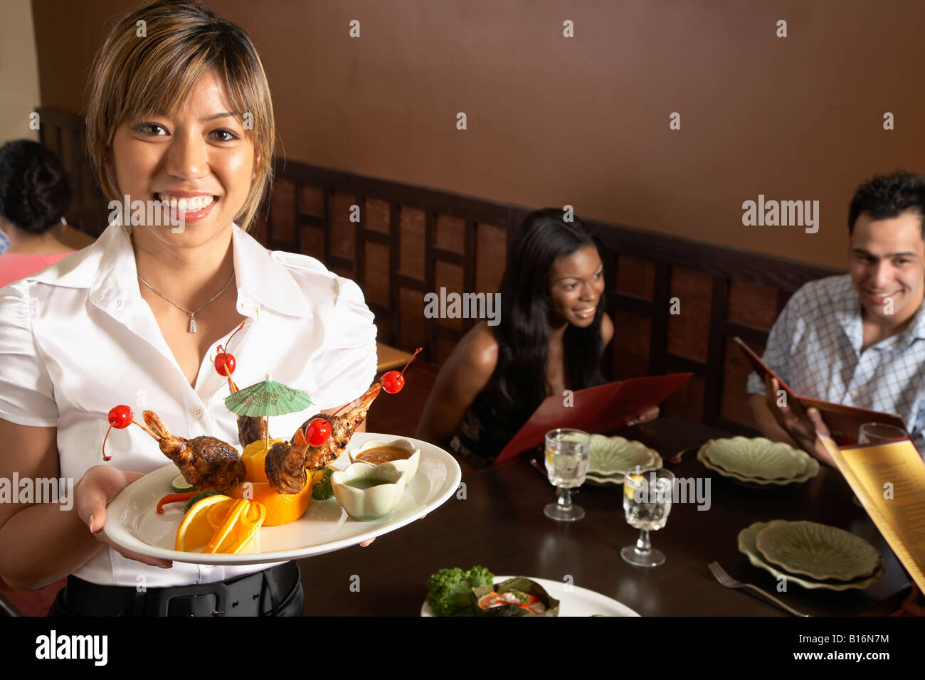 Asian server femmina piastra di contenimento di cibo Foto Stock