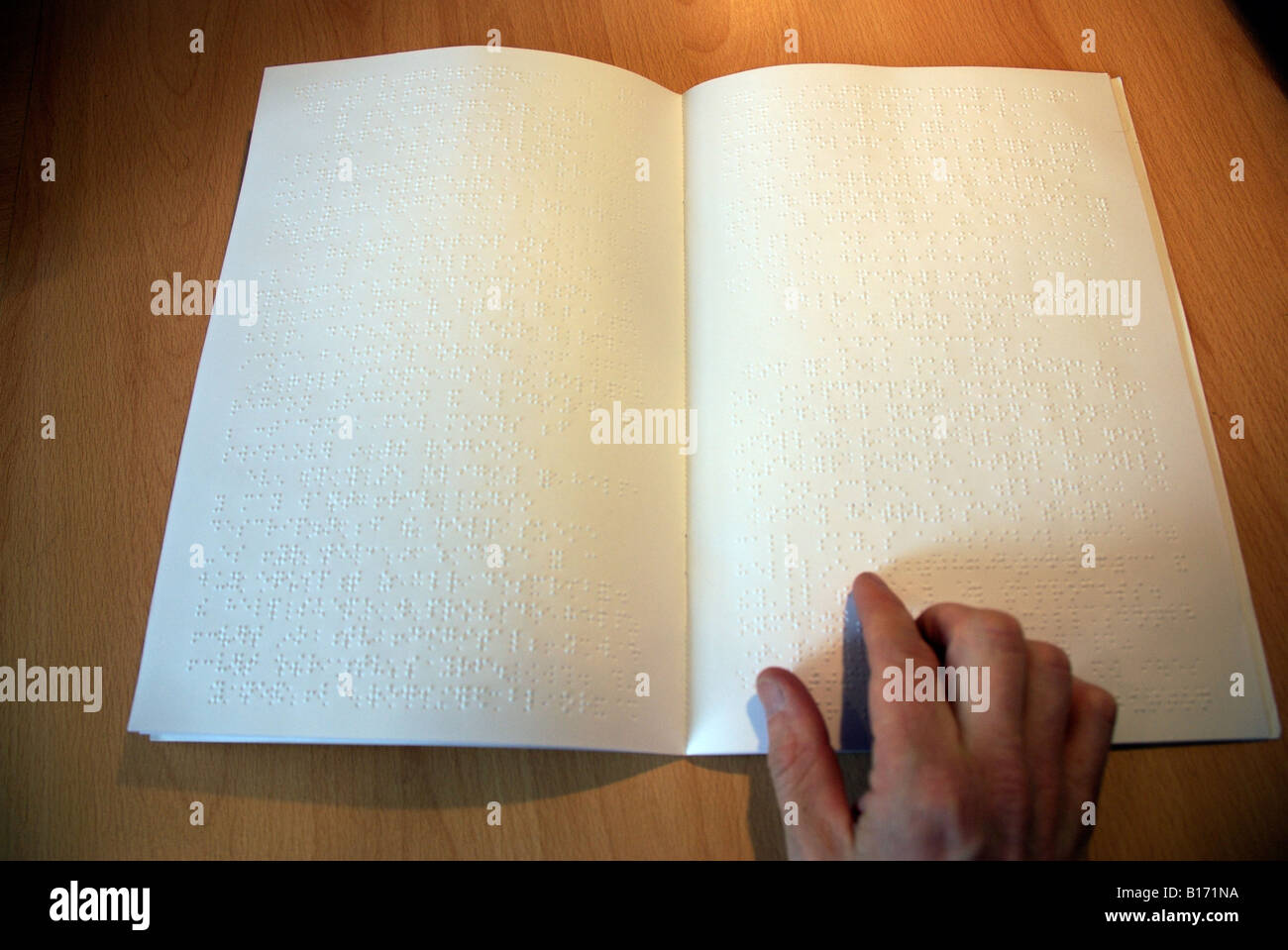 Libro in Braille e la lettura di mano alla scrivania Foto Stock