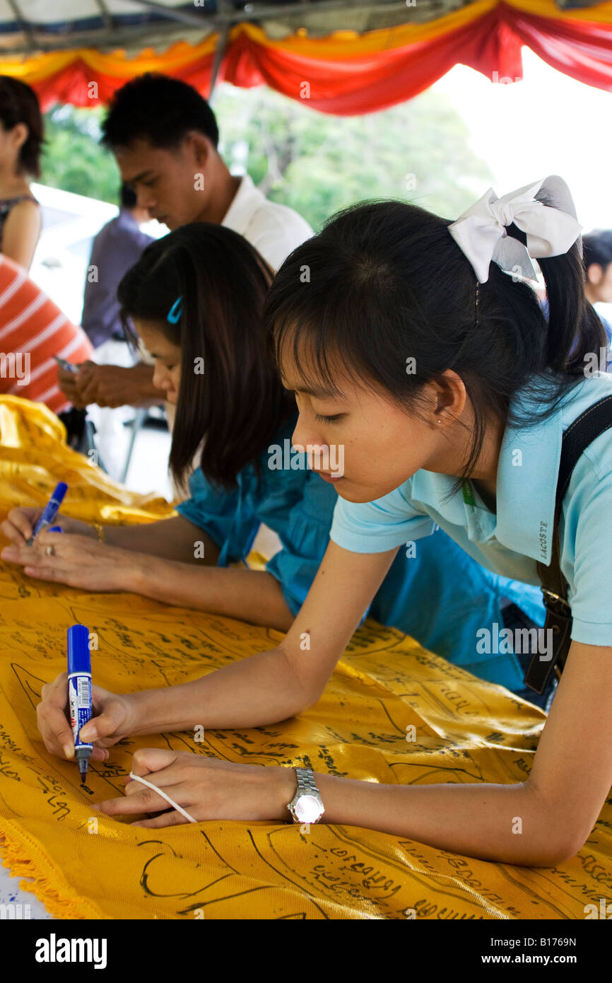 Una donna che scrive i testi sacri su un grande pezzo di tessuto che sono tradizionalmente avvolto intorno ad una torre del tempio Foto Stock