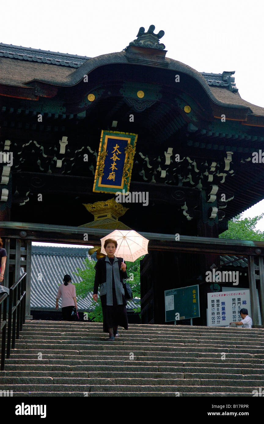 Donna lasciando santo tempio giapponese di Kyoto Foto Stock
