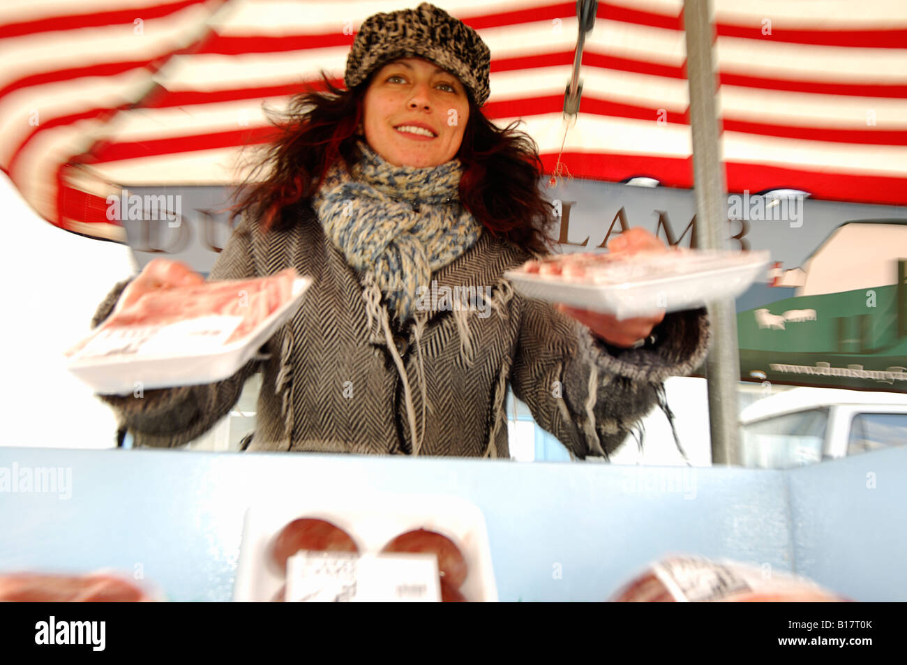 Una ragazza la vendita di agnello in un mercato agricolo Foto Stock