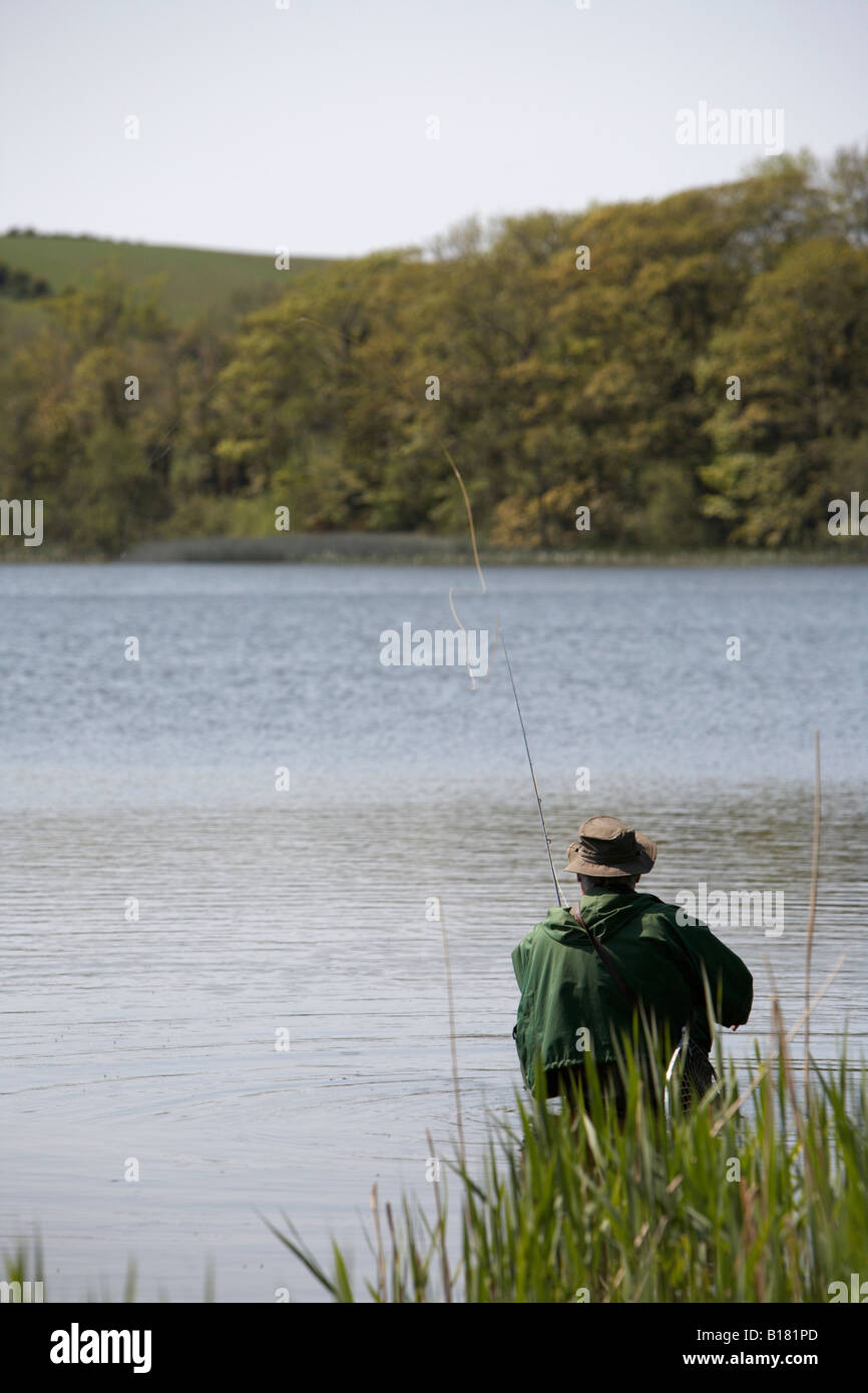 Uomo di colata asta di pesca a mosca e la linea in un lago della contea di Down Irlanda del Nord Foto Stock