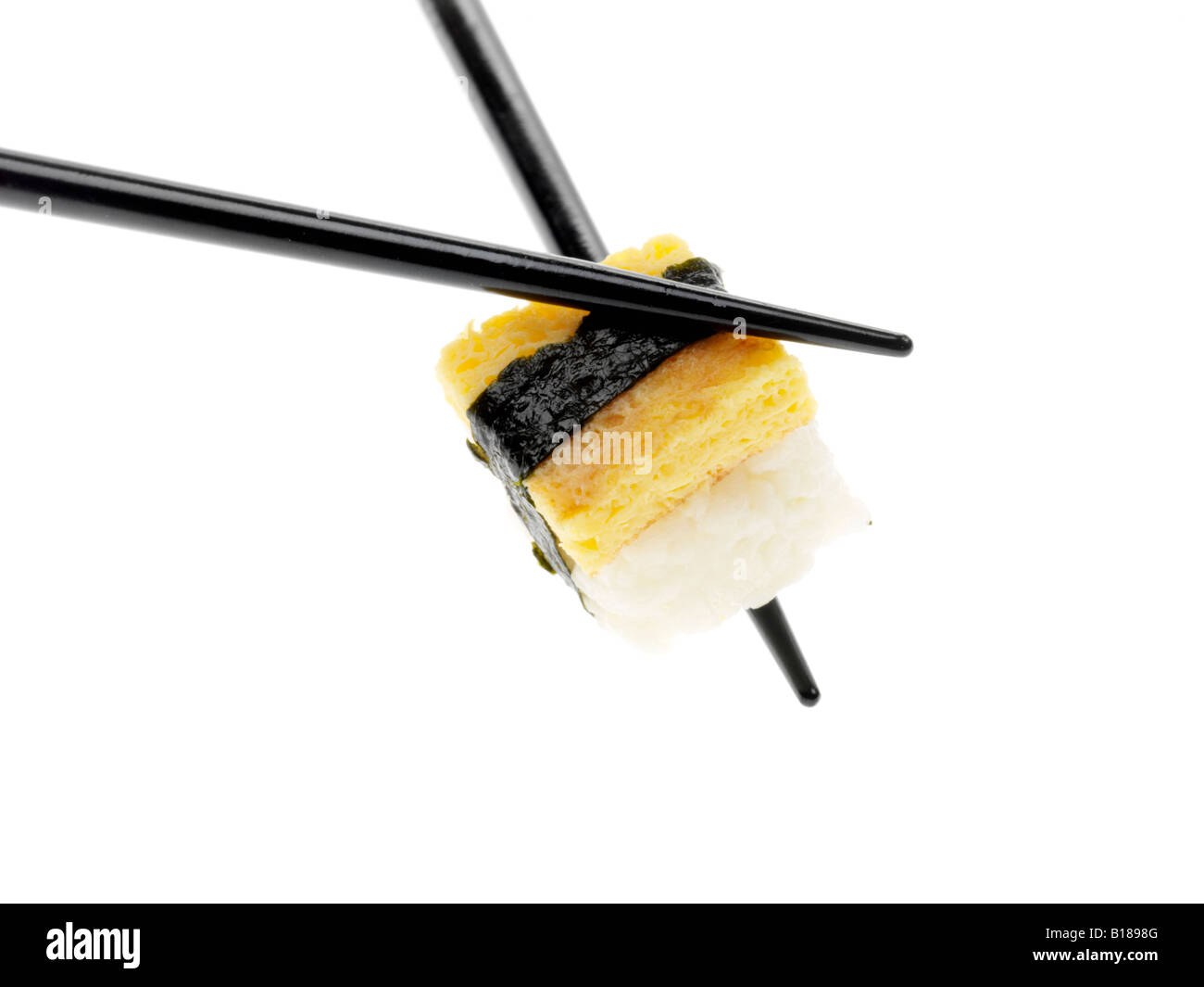 Un autentico stile tradizionale giapponese Sushi snack detenute con bacchette isolata contro uno sfondo bianco con nessun popolo e un tracciato di ritaglio Foto Stock