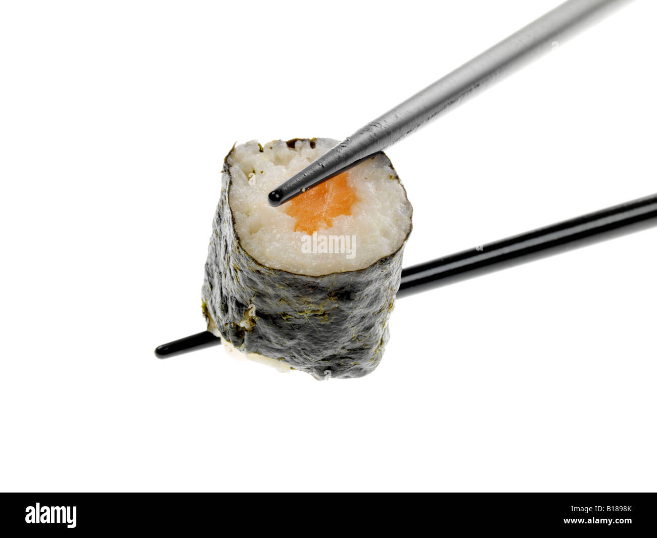 Un autentico stile tradizionale giapponese Sushi snack detenute con bacchette isolata contro uno sfondo bianco con nessun popolo e un tracciato di ritaglio Foto Stock
