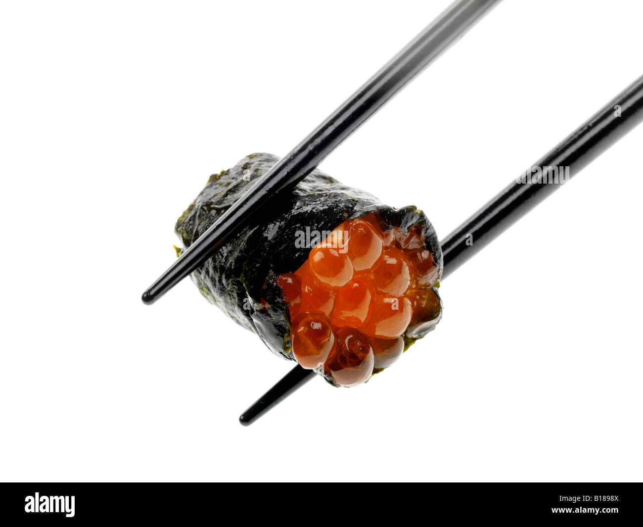 Un autentico stile tradizionale giapponese Sushi snack detenute con bacchette isolata contro uno sfondo bianco con nessun popolo e un tracciato di ritaglio Foto Stock