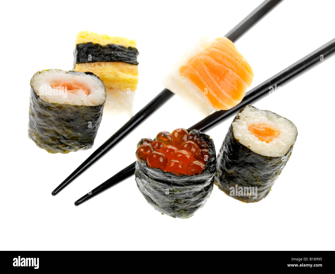 Un autentico stile tradizionale giapponese Sushi snack detenute con bacchette isolata contro uno sfondo bianco con nessun popolo e un tracciato di ritaglio Foto Stock